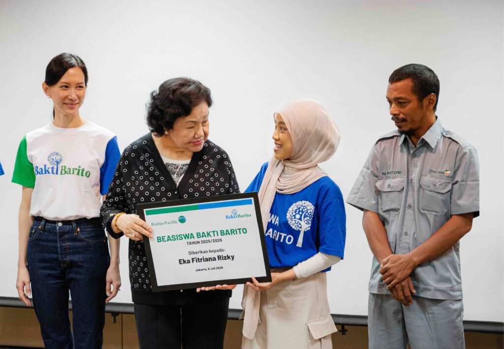 Harlina Tjandinegara presents the Bakti Barito Scholarship award to student Eka, daughter of a Barito Pacific Group employee, at a ceremony.